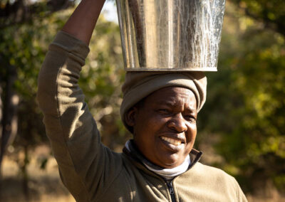 Rosinah carrying warm water for our classic safari bucket showers.